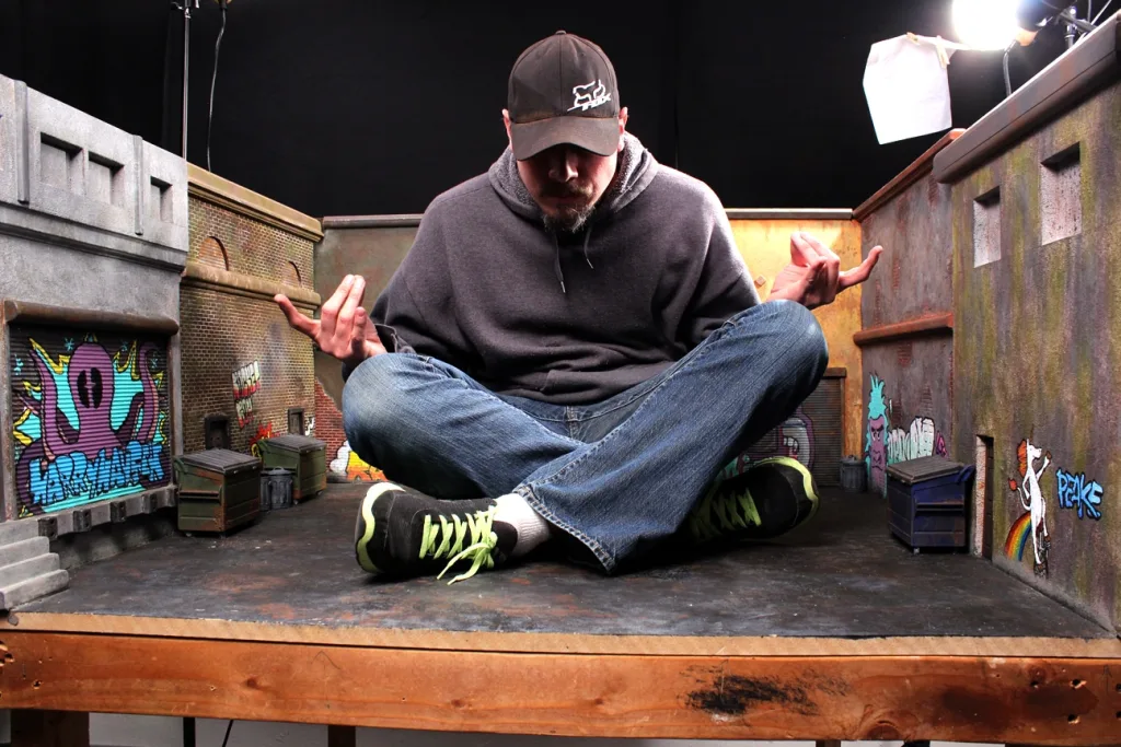 John Ikuma seated inside a miniature stop-motion set